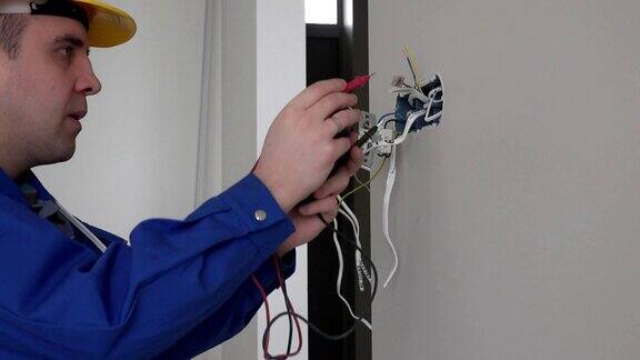 电工用万用表在墙上固定插座上检查插座电压