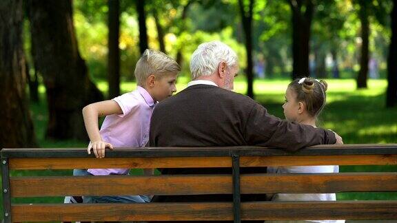 在公园长椅上休息的孩子们和爷爷分享秘密后视镜