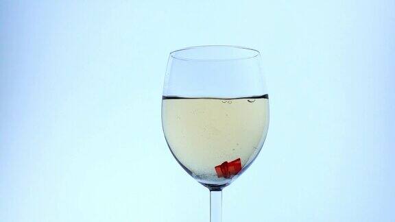 塑料半透明的红色人形落入装满白酒的杯子里在酒精中溺亡