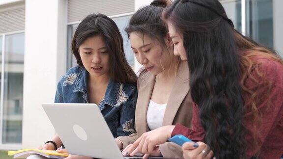 浅聚焦一群东亚女学生在公园里用笔记本电脑学习用4K拍摄