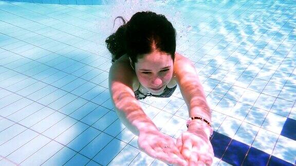 小女孩在游泳池里潜水