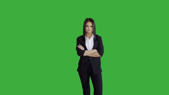 年轻迷人的黑发女人站在孤立的绿色屏幕背景美丽的职业装女人像