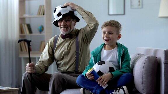 老人和孙子一起看足球一起快乐时光一家人休闲
