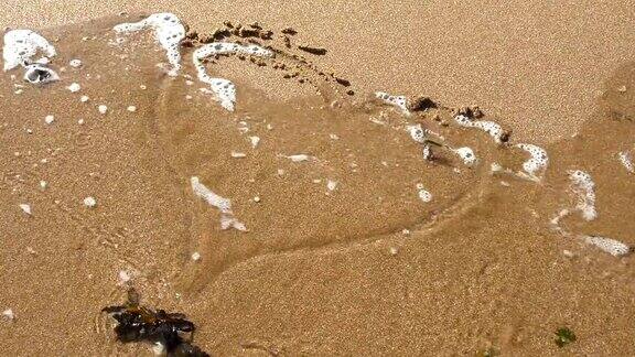 心的形状在沙子里被潮水冲走