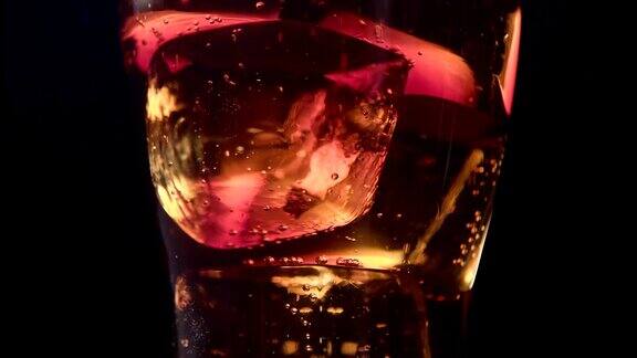 可乐将一个透明的玻璃杯装满冰块黑色背景近距离