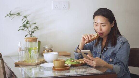 亚裔中国美女在家里享用全麦面包、花生酱和咖啡的早餐