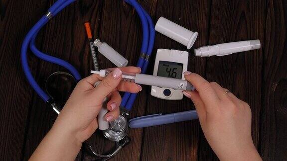 一位患有糖尿病的妇女用胰岛素笔拨出正确剂量的胰岛素糖尿病