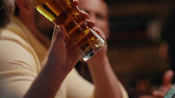 在酒吧里喝啤酒玩手机的男人