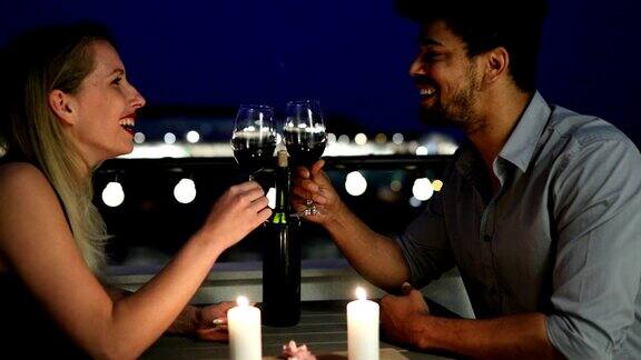 一对年轻美丽的夫妇在屋顶上吃浪漫晚餐