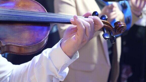 小提琴手在音乐会上在乐队中演奏小提琴