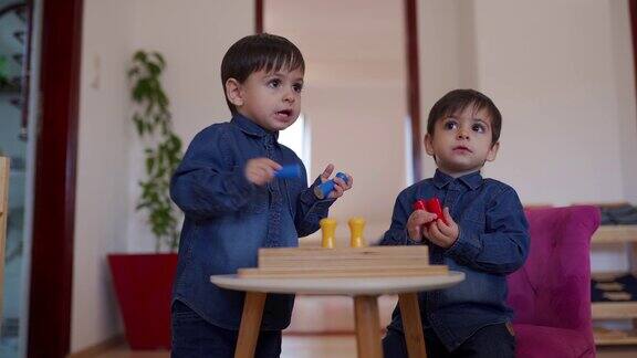 双胞胎男孩在幼儿园教室里玩耍