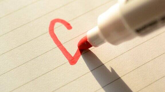 用红色毡尖笔在纸上画一个心形