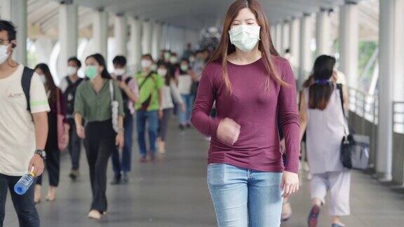 一名亚洲妇女在人群中咳嗽她戴着口罩以预防冠状病毒或新冠肺炎疫情