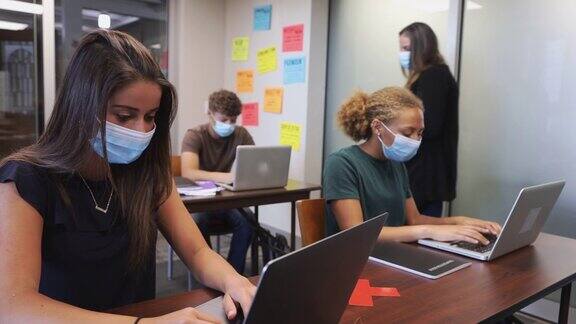 高中男女学生和教师在教室里佩戴面具4K视频