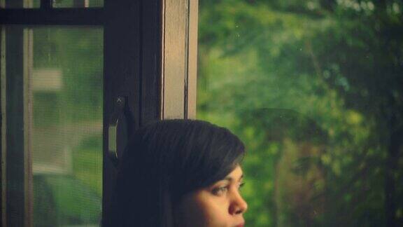 年轻女子沉思着望着窗外的景色