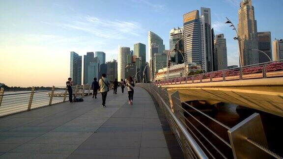 人们走在新加坡滨海湾以摩天大楼为背景