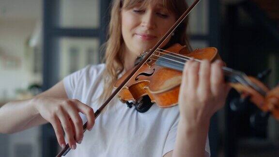 在家里学拉小提琴的女人浪漫的女孩用弓拉小提琴