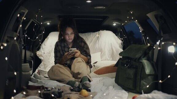 年轻女子晚上在车里露营