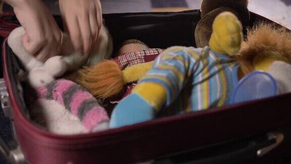 男孩把玩具放在行李箱里准备上路旅行