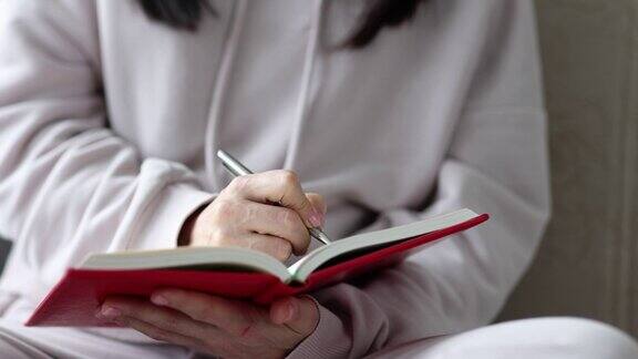女人在家里用手写日记在沙发上特写