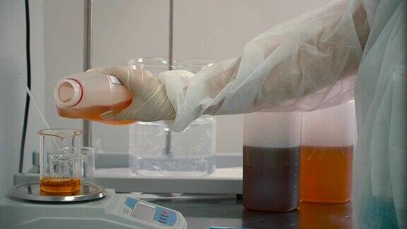 药剂师在电子秤上往烧瓶里倒橙汁实验室