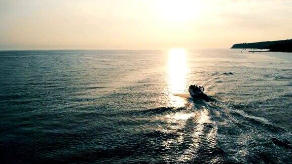 快艇在日落时漂浮在开阔的水面上