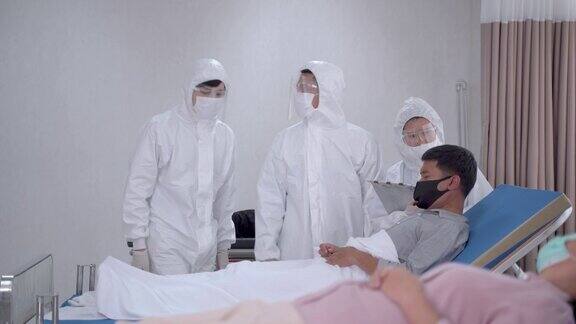 医生穿个人防护服在医院的无尘室护士正在检查戴口罩的病人患病的人患有Covid-19或冠状病毒病