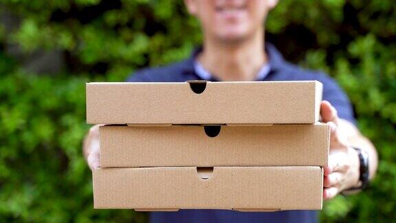 送披萨的男孩拿着披萨盒子在家门口的花园