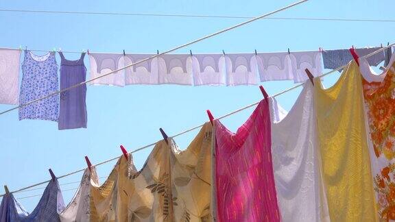 特写:彩色的床单衣服和毛巾被挂在夏天的空气中晾干