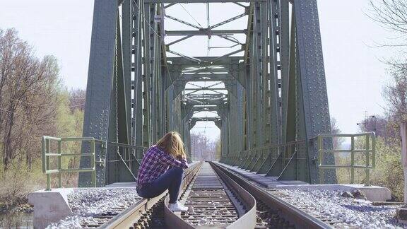 一个孤独的女人坐在铁轨上
