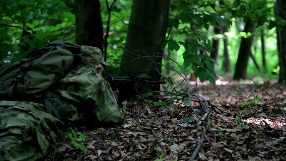 游击队游击战士狙击手带着枪在森林伏击中瞄准