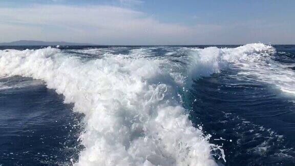 一艘大船驶过带着泡沫状的波浪和浪花