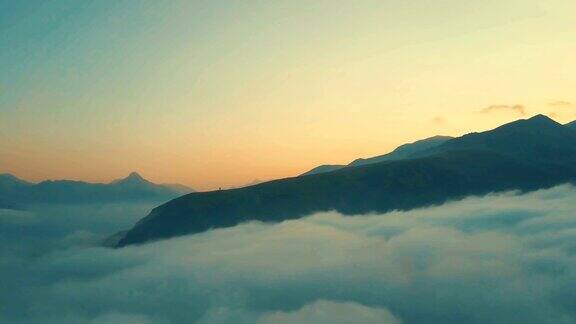 无人机飞越山脉在日落时云彩4K
