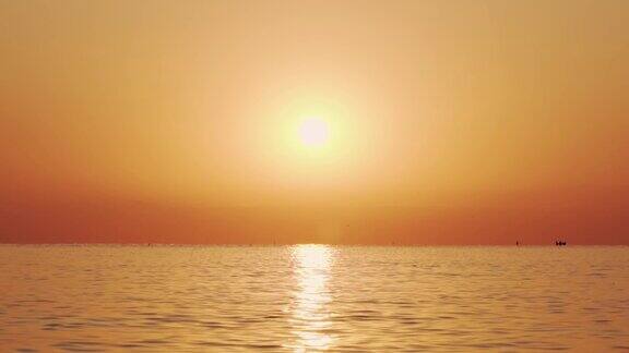 海面的缓慢运动与小波浪的背景日出的太阳一个巨大的太阳圆盘从海面升起这是太阳在水面上的路径金色的海上全景