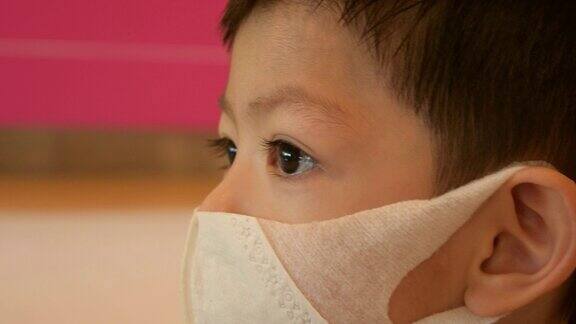 亚洲小男孩戴上卫生防护口罩预防新冠肺炎疫情