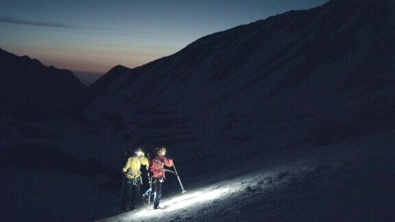 母亲和女儿的登山运动员在黎明攀登雪山脊