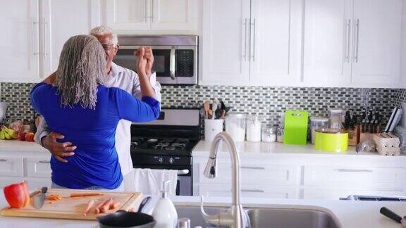 老年黑人夫妇一边在厨房做饭一边跳舞