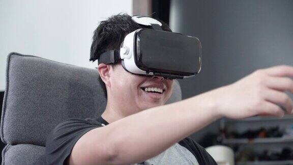 亚洲男人在家里的沙发上使用虚拟现实耳机