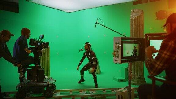在大电影制片厂专业摄制组拍摄大片导演命令摄像机操作员开始拍摄绿色屏幕CGI场景与演员穿着运动跟踪服和头部钻机