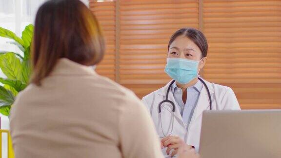 专业的亚洲女医生为患者提供健康咨询为健康生活提供健康咨询在医院穿着白大褂带着听诊器与患者交谈医生和患者