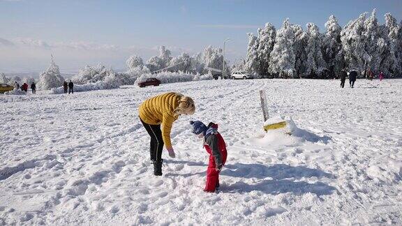 妈妈和她的孩子们在雪地上玩