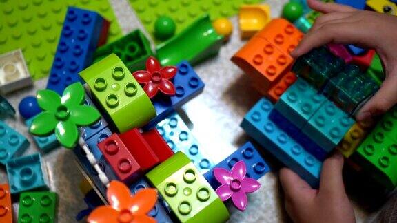 小孩子在室内玩许多五颜六色的塑料玩具
