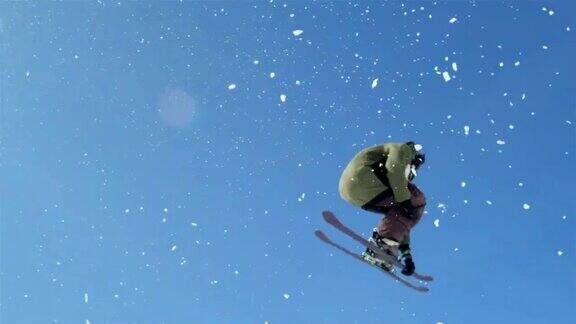 慢镜头特写:自由式滑雪者跳跃大kicker和飞越在雪山的太阳