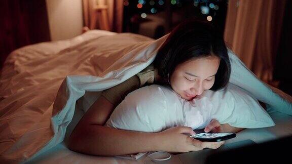 睡眼惺忪的女人在床上玩社交媒体