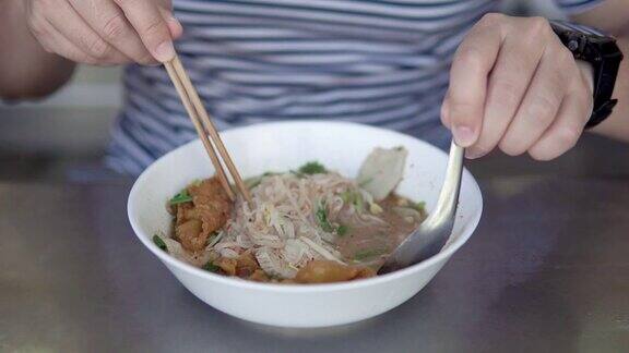 亚洲男子吃泰国猪肉面加汤