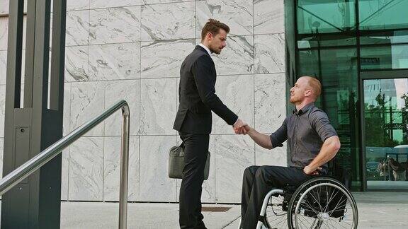 一名商人接近坐在轮椅上的残疾商人并在户外握手