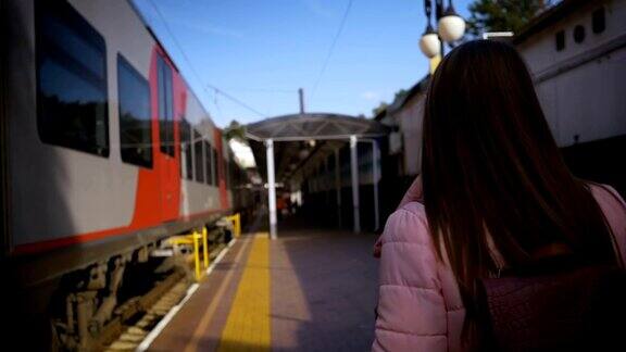 年轻美丽的女子沿着火车站沿着火车走着