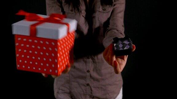 一个女人手里拿着一个大礼品盒和一个小礼品盒供选择