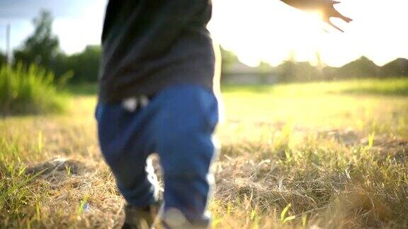 小男孩在高高的草地上奔跑背光照亮