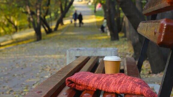 秋日公园空板凳上喝咖啡休息背影人行道上迷离的情侣